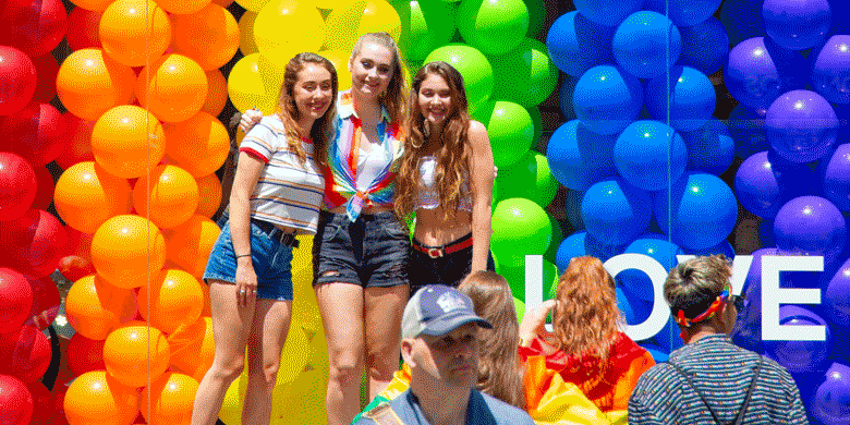 girls posing in front of store balloons